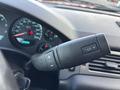 A close-up of the steering wheel controls of a 2011 Chevrolet Avalanche showing buttons for volume and audio settings