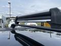 Close-up of a black roof rack mounted on a 2015 Kia Sorento with a glossy surface reflecting the sky