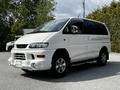 A white 2003 Mitsubishi 7 Passenger Van with a sporty front bumper and chrome accents visible from the side angle