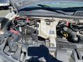 The engine compartment of a 2020 Chevrolet Express showing components like the coolant reservoir battery and various hoses and wires