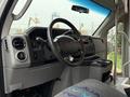 Interior view of a 2014 Ford E-450 featuring a steering wheel dashboard and controls with fabric seats and armrest