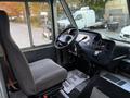 Interior view of a 2012 Ford Econoline with a gray driver's seat and dashboard featuring controls and a steering wheel