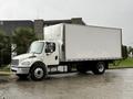 A white 2017 Freightliner M2 106 box truck parked on a concrete surface with a large cargo area and a sleek front design