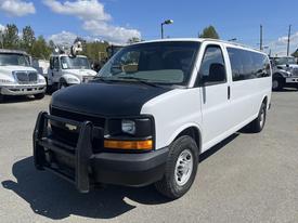 A 2012 Chevrolet Express van in white with a black front grille and brush guard showcasing its spacious design and sturdy build