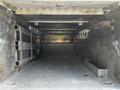 An empty cargo area of a 2016 Ford F-550 featuring a metal floor with storage hooks and compartments along the sides