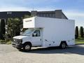 White 2012 Ford Econoline E-450 box truck with a raised roof and side door parked at an angle