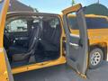 A yellow 2013 Chevrolet Silverado 1500 with the front door open displaying the seating area and interior features