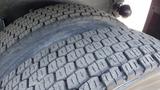 Two large, worn tires of a 2003 International 5600i truck with distinctive tread patterns and grooves visible on the surface