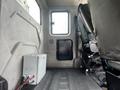 Interior view of a 2008 International 7500 truck cab showing a gray storage box and a driver's seat beside a black passenger seat
