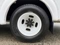 A close-up of a wheel and tire from a 2015 Chevrolet Express featuring a white rim with five lug nuts and a black tire with tread pattern