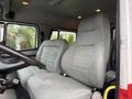 Interior view of a 2001 Freightliner FL80 with two gray fabric seats and a steering wheel in the foreground