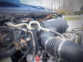 Close-up view of the engine components of a 2005 Ford F-750 including hoses and wiring connected to the engine block