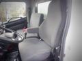 A gray interior of a 2013 Hino 308 truck featuring two upholstered seats with adjustable armrests and a steering wheel