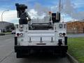 A 2018 Ford F-550 truck with a mounted crane and bucket attached at the rear facing forward