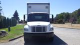 A white 2015 Freightliner M2 106 box truck facing forward with a large cargo area behind the cabin and a distinctive grille design