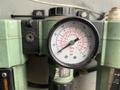 A pressure gauge displaying measurements in MPa bar and psi mounted on a green device