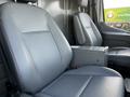 Two gray front seats of a 2017 Ford Transit van with a small storage console between them