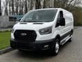 A white 2023 Ford Transit van with a black grille and chrome accents parked on a driveway with side steps and steel wheels