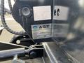 A close-up of a 2024 AGT Industrial QH13R Mini Excavator showing its identification label with model type and serial number