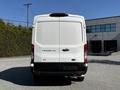 A white 2021 Ford Transit van viewed from the rear with a sleek design and large rear doors
