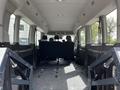 Interior of a 2022 Ford Transit showing rows of black seats and floor with tracks for securing cargo