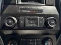 Dashboard controls of a 2016 Ford F-150 featuring knobs for volume and tuning along with buttons for settings and options