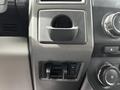 The image shows the interior dashboard of a 2017 Ford F-250 with a cup holder and control knobs for ventilation and other functions