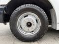 Close-up of a black tire mounted on a silver wheel designed for a 2015 Ford F-350 SD showing detailed tread and wheel studs