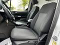 Interior view of a 2019 Ford Transit Connect showing two front seats with black fabric upholstery and a steering wheel visible in the foreground