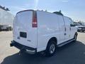 A white 2016 GMC Savana van with a simple design featuring a large cargo area and side sliding door