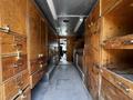 Interior view of a 2008 Morgan Olson Workhorse showing wooden cabinets and drawers lining both sides of a central aisle