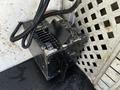 A black electrical component with wires attached, featuring ventilation grills and a switch, likely part of a system in a 2004 Freightliner M2