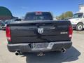 Black 2011 RAM 1500 truck viewed from the back showcasing its tailgate and rear bumper with exhaust pipes on either side