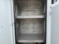 An empty cargo space inside a 2005 Freightliner M2 106 with two metal shelves and smooth walls