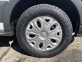 A close-up view of a silver wheel rim with a distinct design mounted on a rugged tire suitable for off-road use