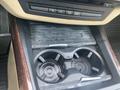 A close-up view of the center console in a 2009 BMW X5 showing a cup holder with a textured surface and several buttons above it for vehicle settings
