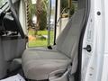 A gray fabric driver's seat in a 2009 Ford Econoline van with a control panel and door visible nearby