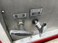 A close-up of controls on a 1991 Sutphen Deluge featuring metallic levers labeled Pump Shift Emergency Override Inlet and Dump Valve