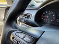 Steering wheel and dashboard controls of a 2018 Kia Rio5 displaying the speedometer and various function buttons