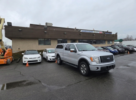 A silver 2014 Ford F-150 parked in a lot with several other cars around it