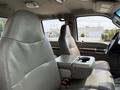 Interior view of a 2008 Ford F-550 featuring two gray leather seats and a central armrest with a cup holder