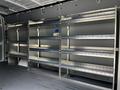 A 2023 Mercedes-Benz Sprinter van interior featuring multiple metal shelves organized for storage