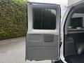 A 2008 Ford Econoline van with an open side door revealing a gray interior panel and storage compartments