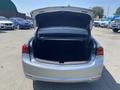 A 2017 Acura TLX with its trunk open showing a spacious, empty cargo area