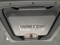 A ceiling hatch with a sign that reads Emergency Exit and a red pull handle in a 2012 Chevrolet Express