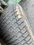Close-up of a worn tire from a 2012 John Deere 1445 SERIES II 4WD showing distinct tread patterns and signs of usage