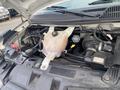 Engine compartment of a 2016 Chevrolet Express showing components like the coolant reservoir and various hoses and wires