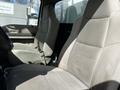 Interior view of a 2008 Ford F-550 showing two beige cloth seats without armrests and a simple dashboard