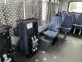 Interior of a 2012 Chevrolet Express showing blue upholstered seats and a wheelchair lift mechanism