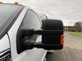 A close-up of the side mirror of a 2013 Ford F-350 SD showcasing its black and orange detailing